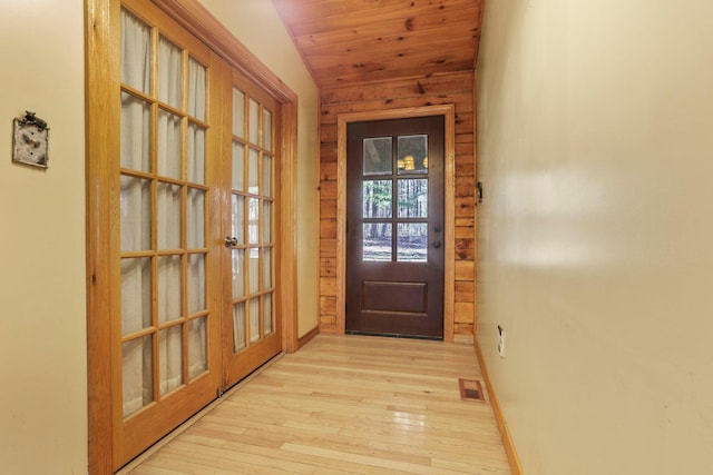 doorway featuring wood ceiling, light hardwood / wood-style flooring, and vaulted ceiling