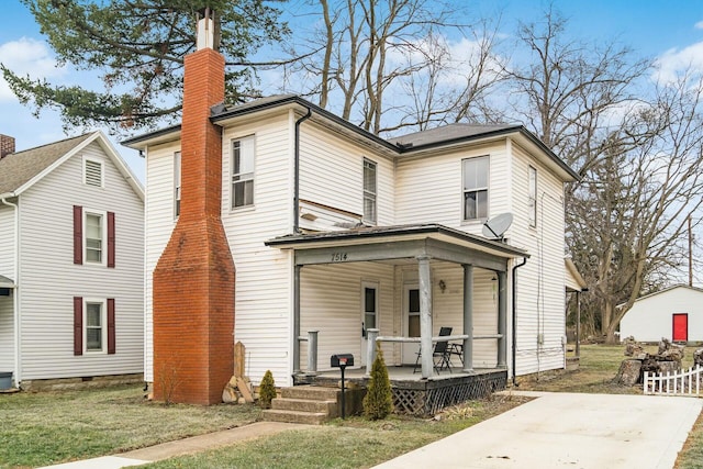 view of front of property featuring covered porch, a chimney, and a front lawn