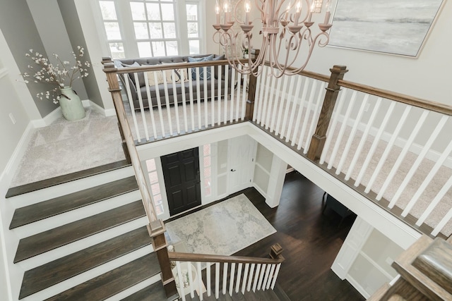 staircase with wood-type flooring and a chandelier