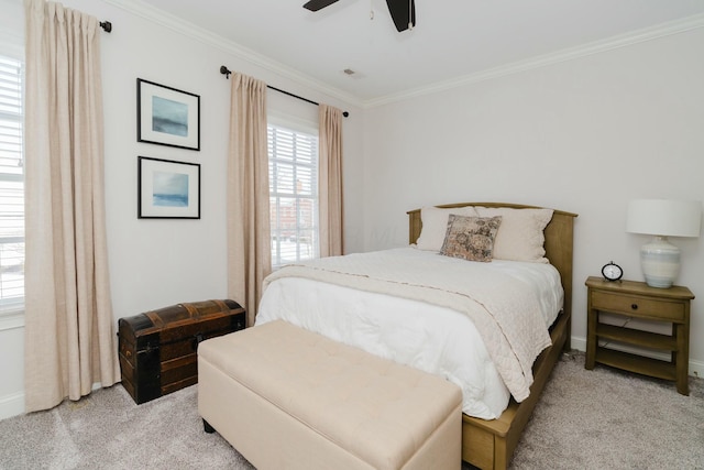 carpeted bedroom with ornamental molding and ceiling fan