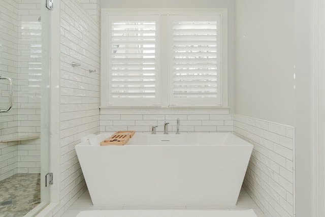 bathroom with tile walls and plus walk in shower