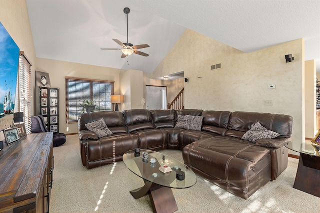 carpeted living room with ceiling fan and high vaulted ceiling