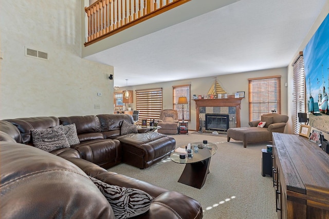 living room with a tile fireplace and carpet flooring