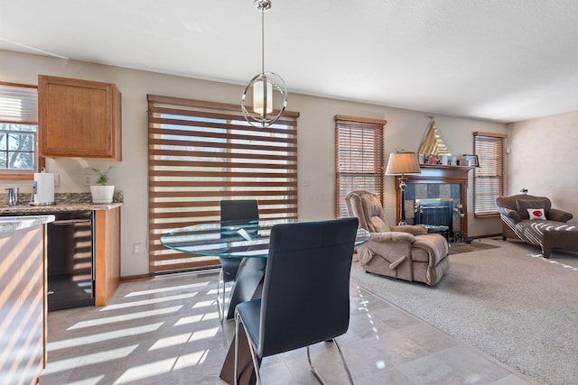 dining space with a tiled fireplace and light carpet