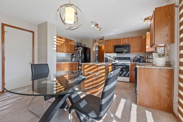 kitchen with decorative light fixtures, black appliances, and light tile patterned flooring