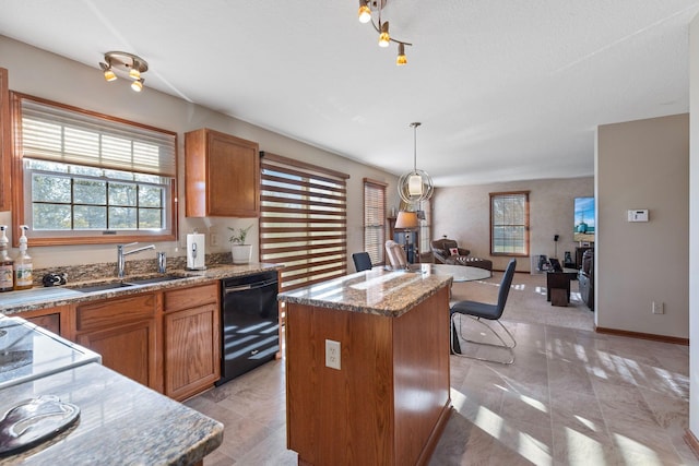 kitchen with sink, decorative light fixtures, a center island, dishwasher, and light stone countertops