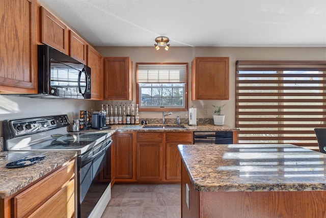 kitchen with light stone counters, sink, and black appliances