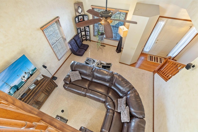 carpeted living room with ceiling fan