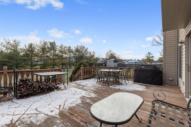 wooden terrace with area for grilling and a shed