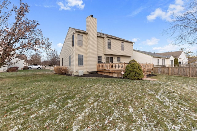 back of house featuring a wooden deck and a yard