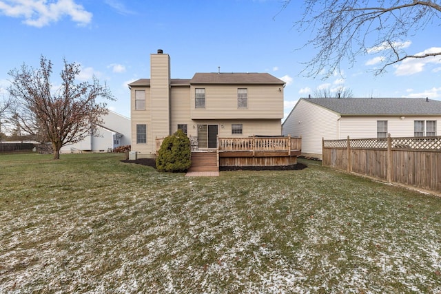 back of house featuring a wooden deck and a lawn