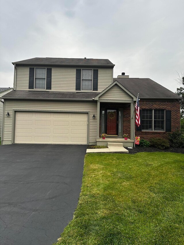 5037 Langcroft Dr, Hilliard, OH 43026 - traditional-style home featuring a garage, asphalt driveway, a front yard, and brick siding