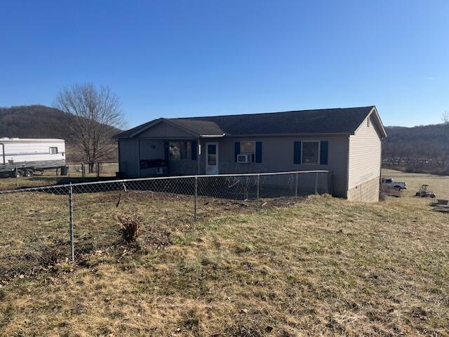 rear view of house featuring a lawn