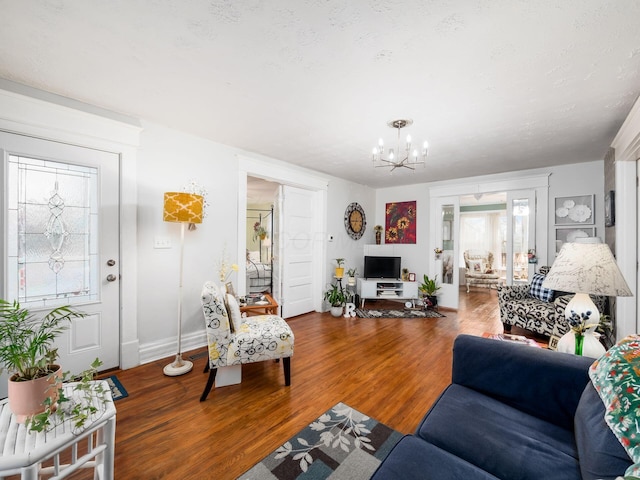 living room with hardwood / wood-style flooring, a textured ceiling, and a notable chandelier