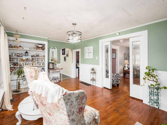 living room with crown molding, dark hardwood / wood-style flooring, and a textured ceiling