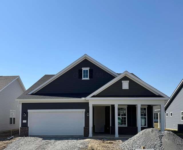 view of front of property featuring cooling unit, brick siding, and a porch