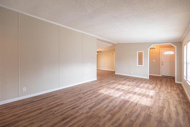 unfurnished living room with hardwood / wood-style flooring, crown molding, and a textured ceiling