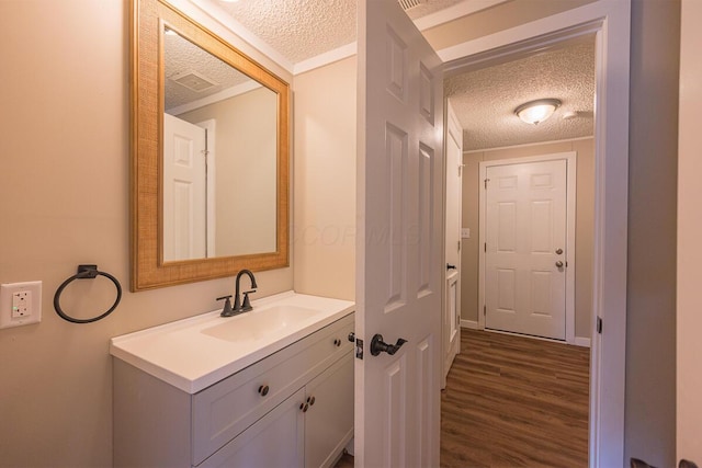 bathroom with vanity, wood-type flooring, and a textured ceiling