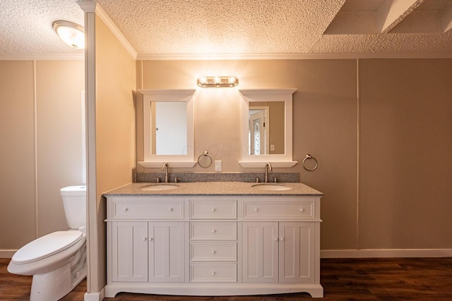 bathroom featuring hardwood / wood-style flooring, vanity, toilet, and a textured ceiling