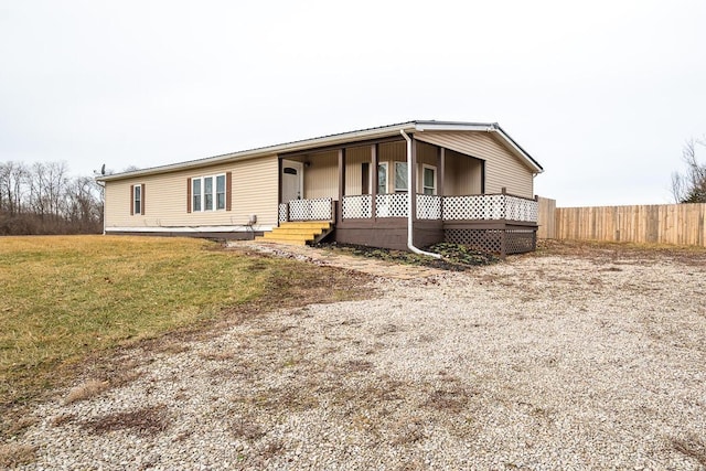 manufactured / mobile home with covered porch and a front lawn