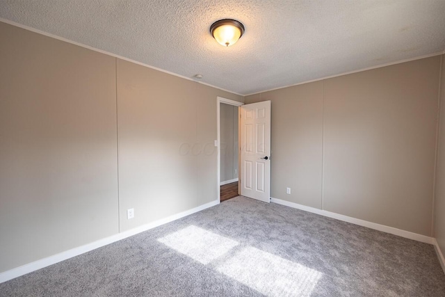 carpeted spare room with ornamental molding and a textured ceiling