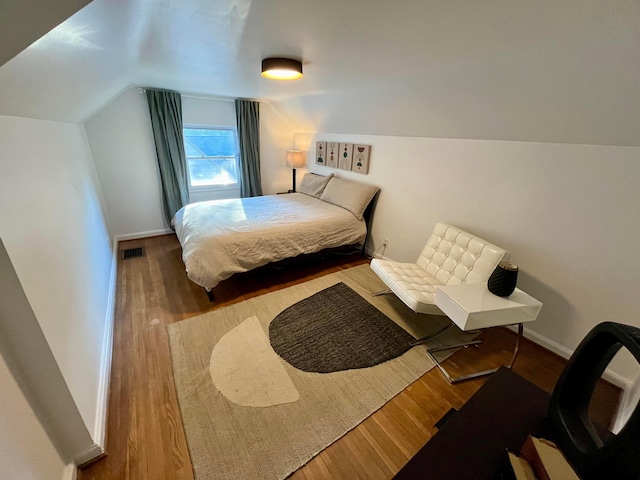 bedroom with hardwood / wood-style flooring and vaulted ceiling