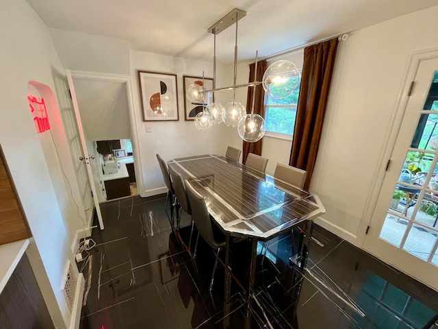 dining space featuring dark tile patterned floors