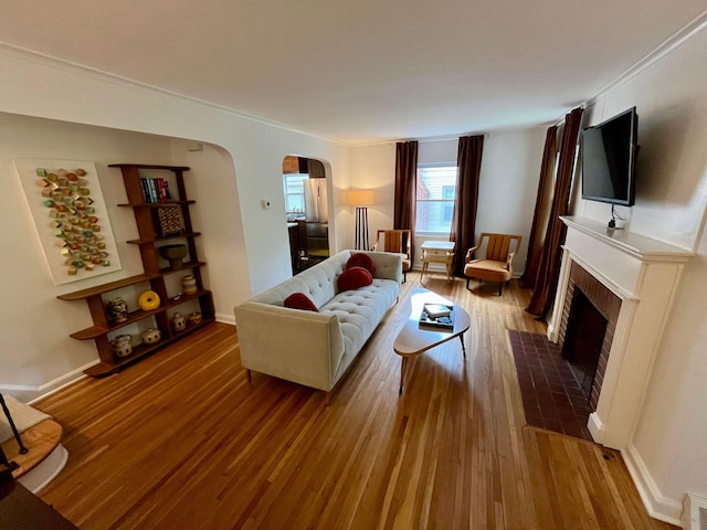 living room with wood-type flooring and a tile fireplace