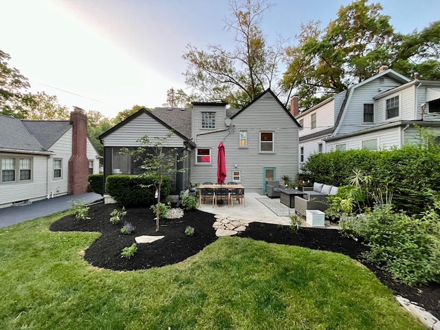 rear view of house featuring a yard, a patio area, outdoor lounge area, and a sunroom