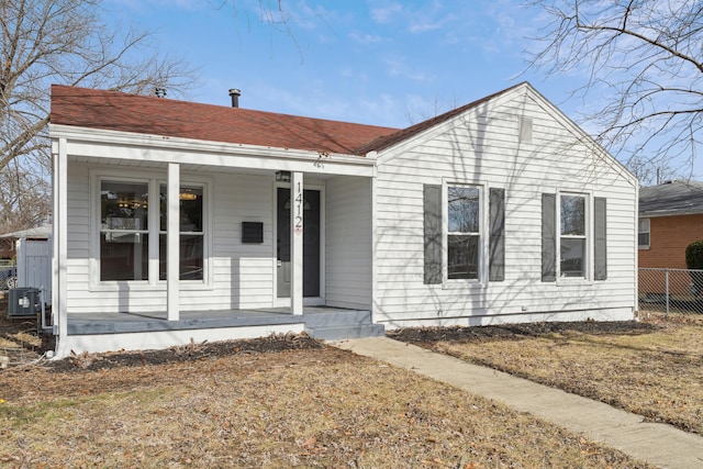 bungalow featuring central AC unit, covered porch, and a front lawn