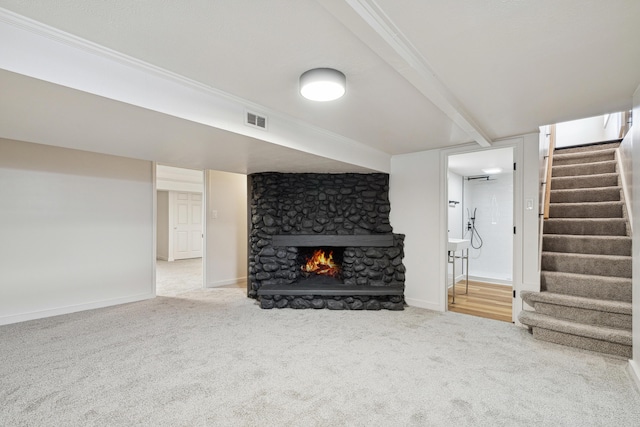 unfurnished living room featuring beam ceiling, carpet floors, and a fireplace