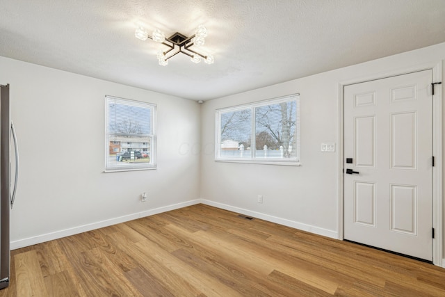 interior space featuring a textured ceiling and light wood-type flooring