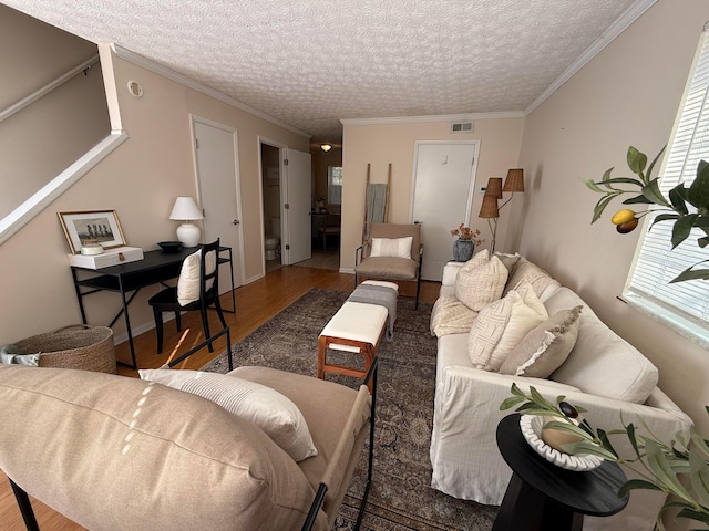 living area featuring a textured ceiling, crown molding, and wood finished floors