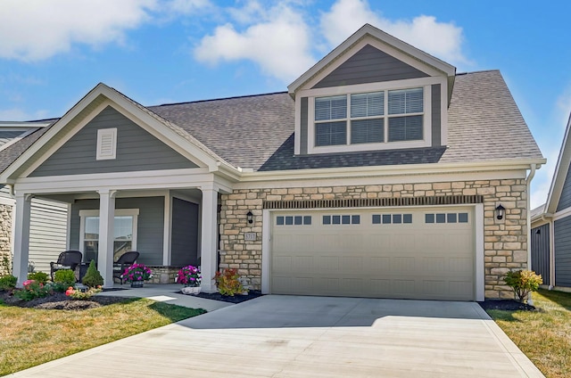 view of front of property with a garage, covered porch, and a front yard