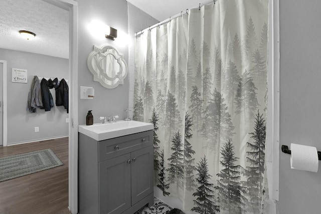 bathroom featuring vanity, wood-type flooring, a textured ceiling, and a shower with curtain