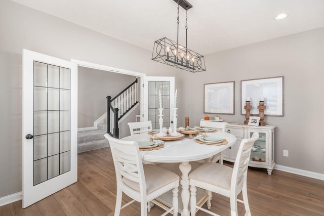 dining room with hardwood / wood-style floors and a notable chandelier