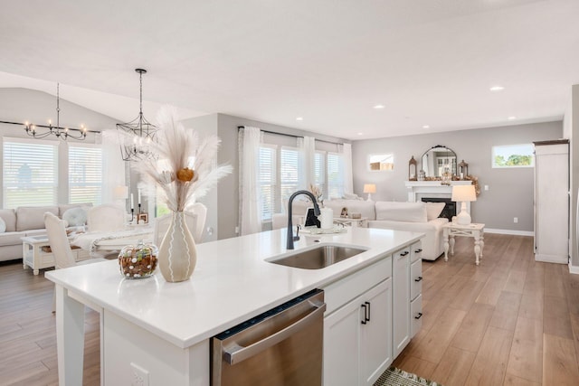 kitchen with sink, white cabinetry, a center island with sink, dishwasher, and pendant lighting