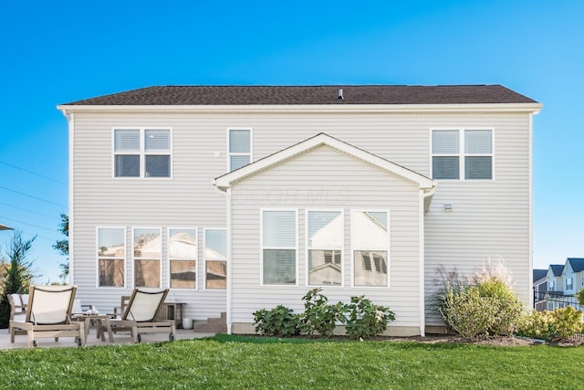 rear view of property featuring a patio area and a lawn