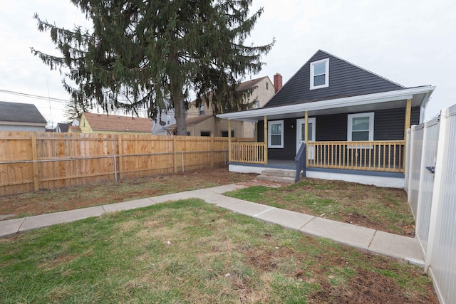 view of front of home with covered porch and a front lawn