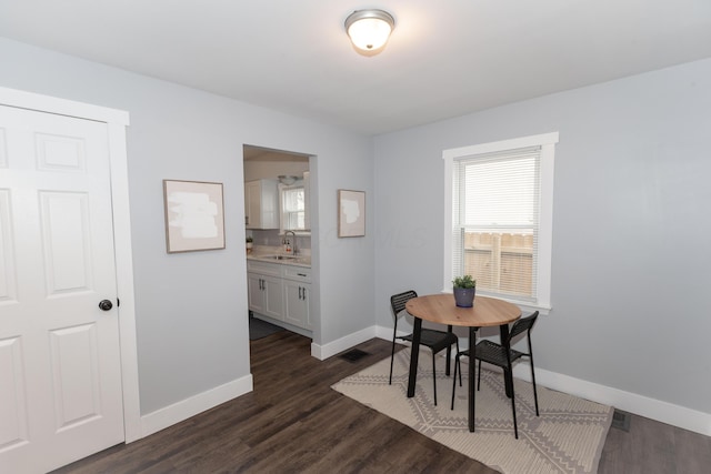 dining space featuring dark wood-type flooring and sink