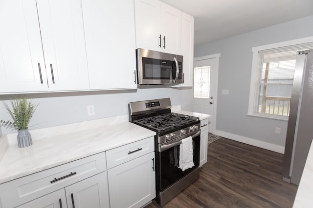 kitchen with appliances with stainless steel finishes, dark hardwood / wood-style floors, and white cabinets