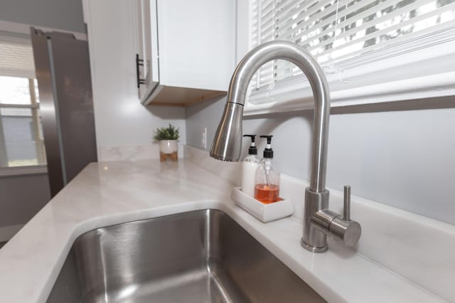 details featuring white cabinetry and sink