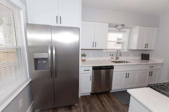 kitchen featuring appliances with stainless steel finishes, dark hardwood / wood-style flooring, sink, and white cabinets