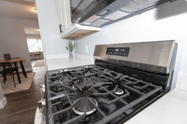 room details with dark hardwood / wood-style flooring, gas stove, and white cabinets