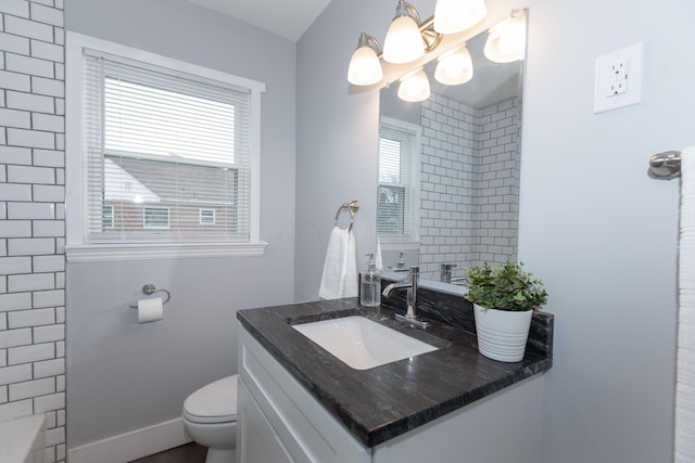 bathroom featuring vanity, an inviting chandelier, and toilet