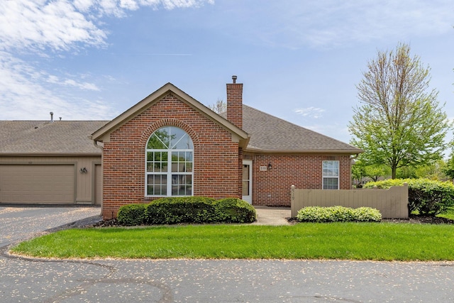 view of home's exterior with brick siding, an attached garage, driveway, and a chimney