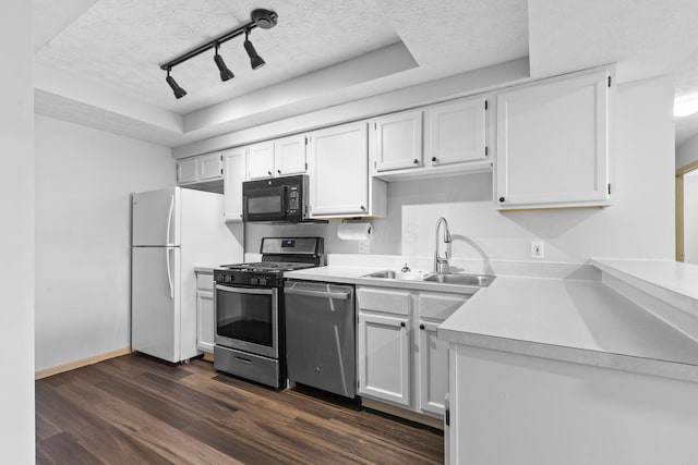 kitchen with track lighting, light countertops, white cabinetry, a sink, and appliances with stainless steel finishes