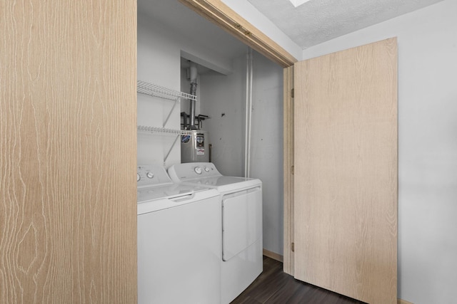 clothes washing area featuring laundry area, a textured ceiling, dark wood-style floors, washer and dryer, and electric water heater