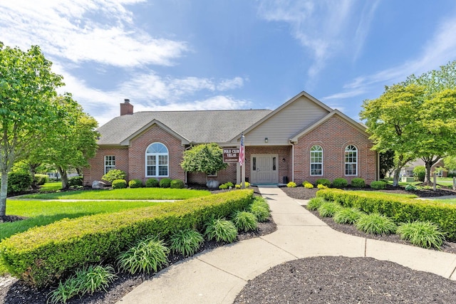 ranch-style house featuring brick siding and a chimney