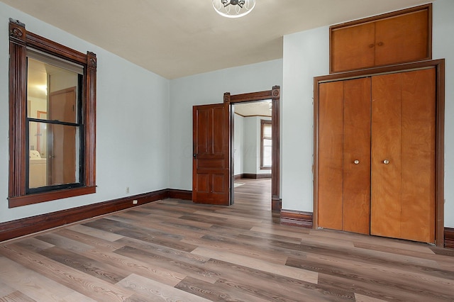 unfurnished bedroom with light hardwood / wood-style flooring and a closet